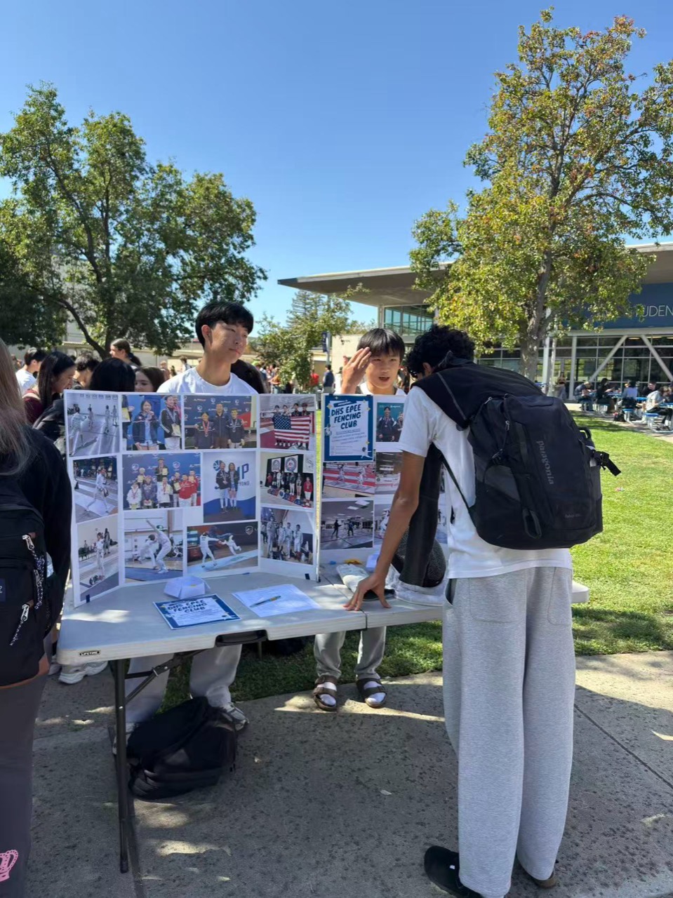 Students speaking with the Davis High School Épée Fencing Club at its club fair table