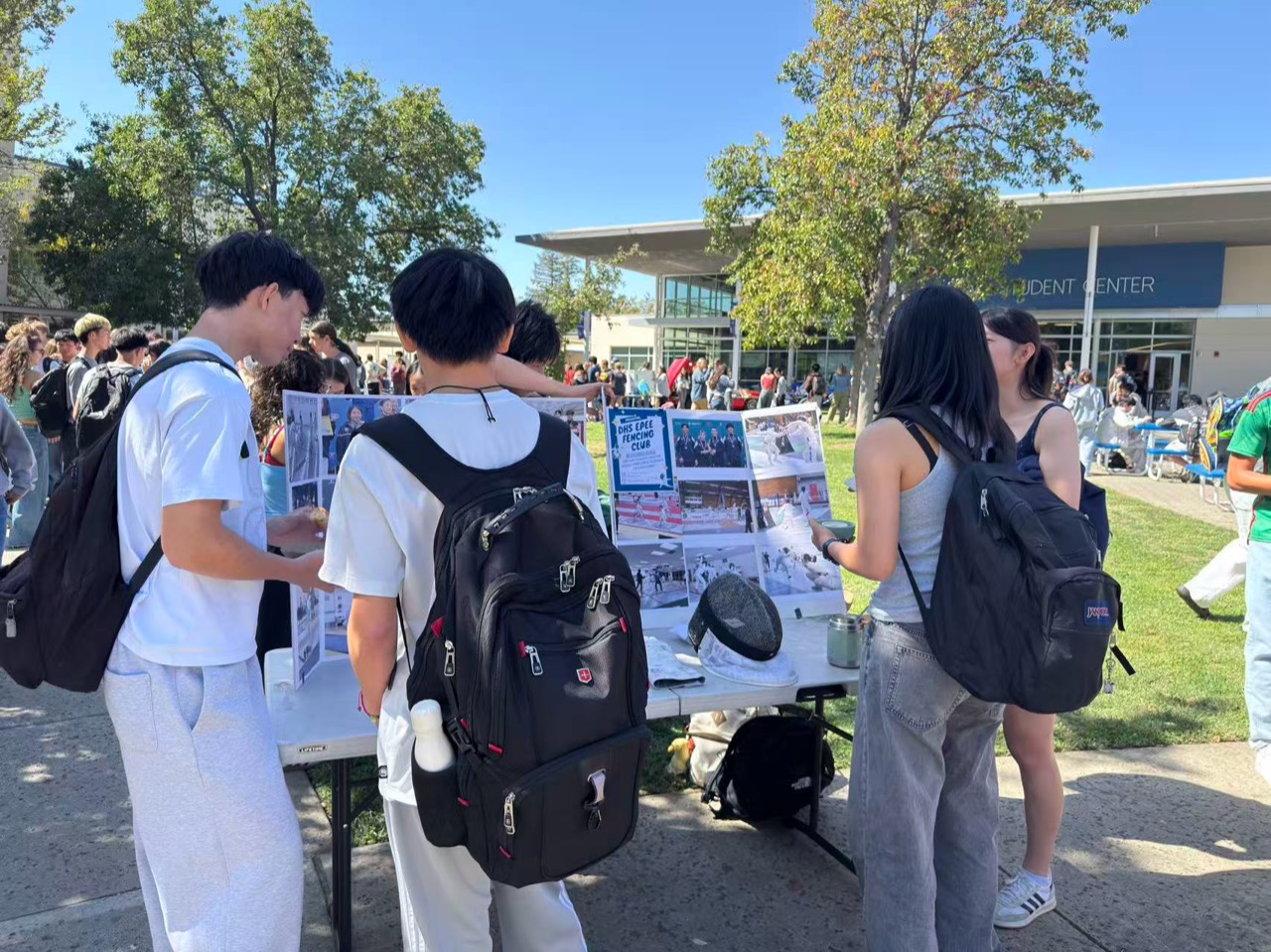 Students gathering around the Davis High School Épée Fencing Club display