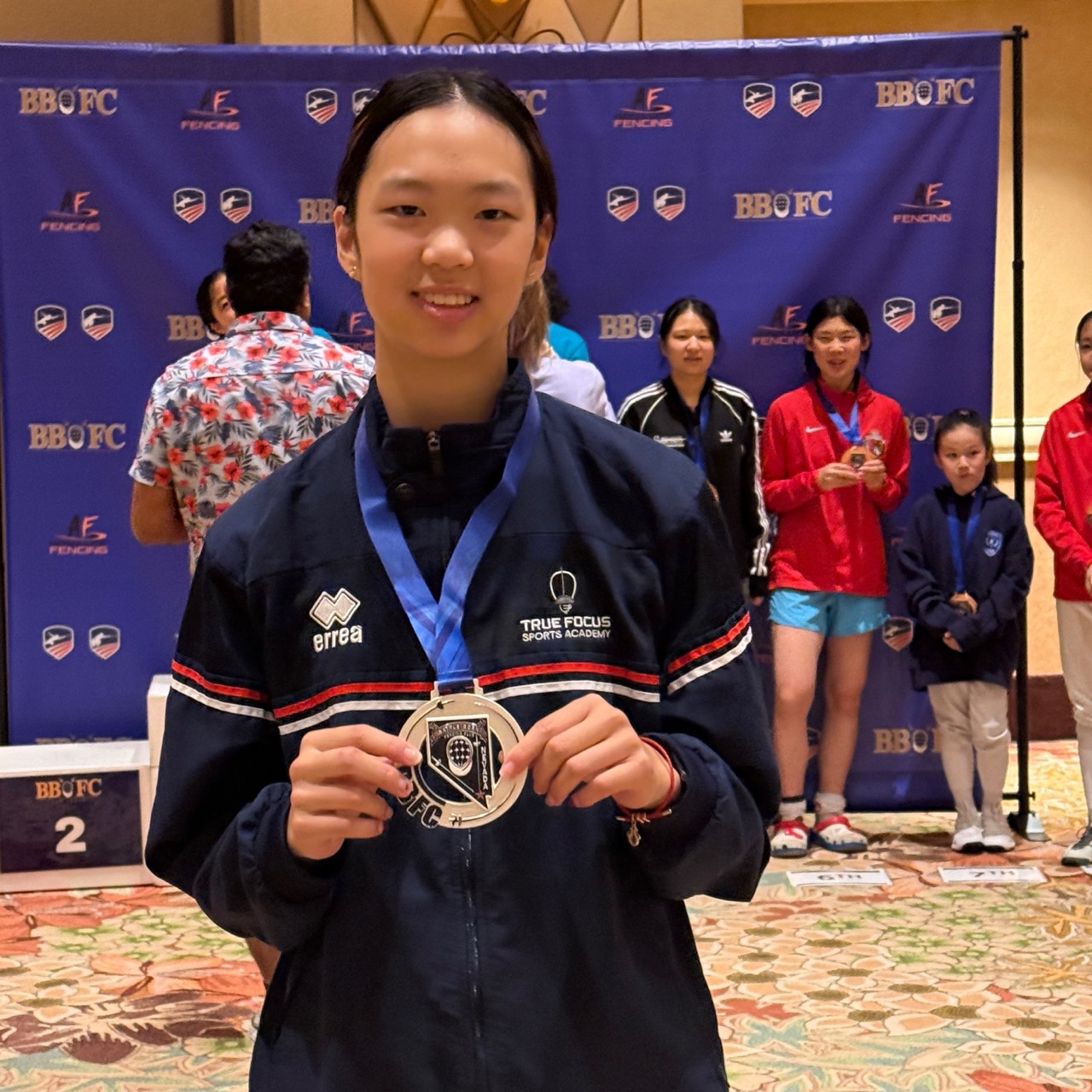 Amy Xu holding her silver medal at the BBFC Duel in the Desert awards presentation